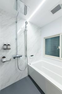a white bathroom with a tub and a window at BLIKIYA Doma in Fujiyoshida +41 photos