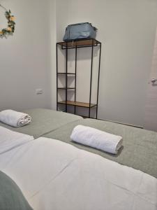 a bedroom with two white towels on a bed at Pinedo Playa Holiday 2 in Valencia