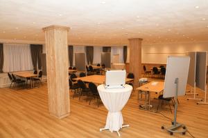 a conference room with tables and chairs and a podium at Schwaben Resort Ebnisee in Ebni