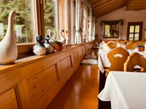 a dining room with tables and vases on the windows at Hotel Tannenhof in Egmating