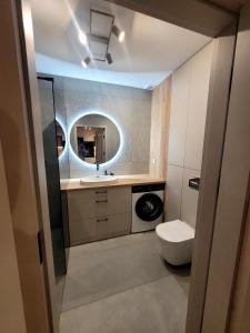 a bathroom with a toilet and a sink and a mirror at Apartament Lubawka in Lubawa
