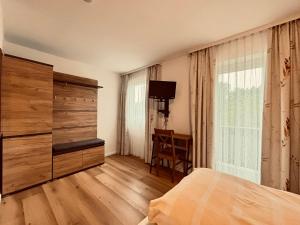 a bedroom with a bed and a dresser and a window at Hotel Tannenhof in Egmating