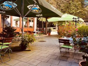 a patio with tables and chairs and an umbrella at Hotel Tannenhof in Egmating