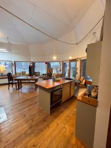 a large kitchen and living room with wooden floors at Art space Bundulis in Saulkrasti