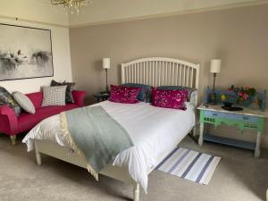 a bedroom with a large bed and a red couch at Bryn Mair Gardens in Dolgellau