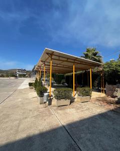 a pavilion with plants in pots on a sidewalk at Caco Camper Parking in Berat