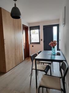 a dining room table with chairs and a vase of flowers at Modern 4 stars Apartment with terace & free parking in Šibenik