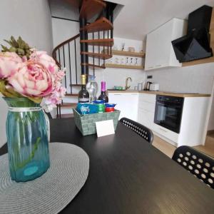 a vase with pink flowers on a table in a kitchen at Modern 4 stars Apartment with terace & free parking in Šibenik +11 photos