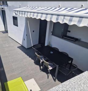 a black table and chairs under a white awning at Modern 4 stars Apartment with terace & free parking in Šibenik
