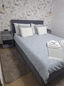 a bedroom with a bed with pillows and a rug at Modern 4 stars Apartment with terace & free parking in Šibenik