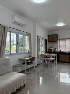 a living room with a couch and a table and chairs at Cheeva Home #1 in Ban Pa Tung (7)