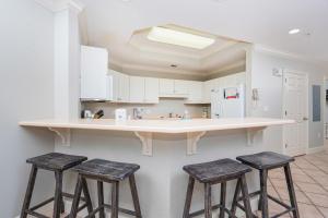 a kitchen with two bar stools and a counter at Phoenix on the Bay 1124 in Orange Beach
