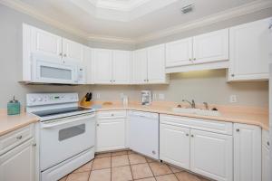 a kitchen with white cabinets and white appliances at Phoenix on the Bay 1124 in Orange Beach