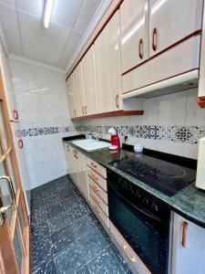 a kitchen with white cabinets and black counter tops at Casa caloret -Playa y centro a 2 min - 1ªPlanta in Vinarós