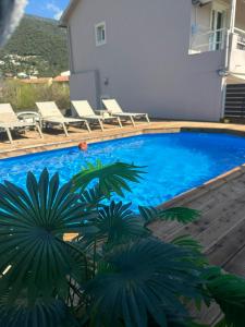 a swimming pool with chaise lounge chairs next to a house at Evelina Luxury Suites with Swimming Pool in Corfu in Ipsos