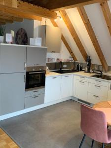 a kitchen with white cabinets and a table and chairs at Ferienwohnung Leonardo in Badem