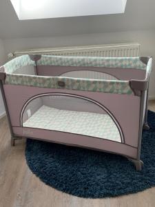 a small pink crib with the top on a rug at Ferienwohnung Leonardo in Badem