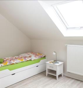 a white bedroom with a bed and a table at Ferienwohnung Leppert in Schwanau