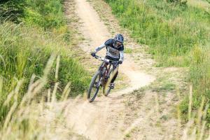 a person riding a bike on a dirt road at Apartament Lubawka in Lubawa +6 photos