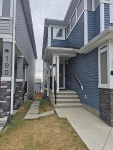 a house with blue siding and a driveway at Authentic Suite in YYC