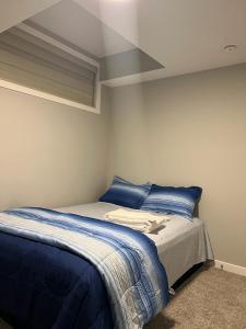 a bedroom with a bed with blue sheets at Authentic Suite in YYC