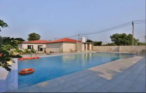 a large swimming pool with a red boat in it at Camp Leo Aaranya Resort in Sasan Gir