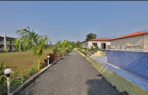 a walkway in front of a house next to a yard at Camp Leo Aaranya Resort in Sasan Gir