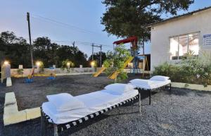 a group of beds in front of a playground at Camp Leo Aaranya Resort in Sasan Gir