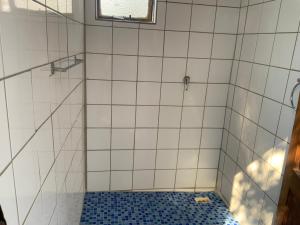 a bathroom with a shower with a blue and white tiles at Lorato Camping in Chobe