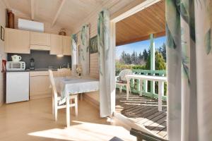 a kitchen and dining area of a tiny house with a balcony at Chalet 2 FLAMANT ROSE in Roquebrune-sur-Argens
