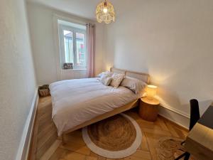 a bedroom with a bed and a chandelier at La Maison de Jacob in La Chaux-de-Fonds