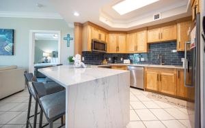 a kitchen with wooden cabinets and a white counter top at Phoenix on the Bay 1328 in Orange Beach