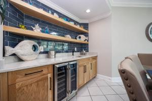 a kitchen with wooden cabinets and blue tiles at Phoenix on the Bay 1328 in Orange Beach