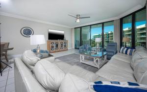 a living room with a white couch and a television at Phoenix on the Bay 1328 in Orange Beach