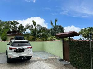a white car parked in front of a fence at Calhetas Suíte 2 in São Sebastião