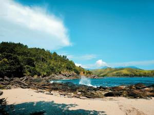 a beach with a bunch of rocks and water at Calhetas Suíte 2 in São Sebastião