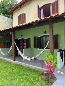 a green house with a hammock in front of it at Calhetas Suíte 2 in São Sebastião