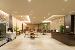 un restaurante con mesas y sillas en un edificio en The Empress Hotel en Daejeon