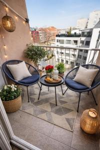 a patio with two chairs and a table on a balcony at Iva Penthouse in Novi Sad