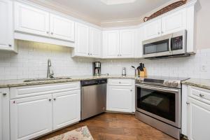 a kitchen with white cabinets and a sink and a microwave at Phoenix on the Bay 1109 condo in Orange Beach