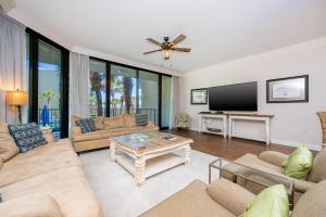 a living room with a couch and a tv at Phoenix on the Bay 1109 condo in Orange Beach