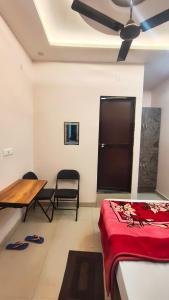a room with a bed and a table and a ceiling fan at Royal guest house in Gorakhpur