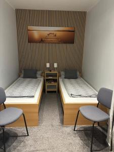 two beds in a room with two chairs at Apartment in der Eifel in Blankenheim