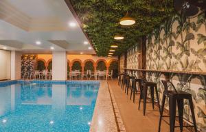 a pool in a hotel with chairs and tables at Hotel Magenta-City Center Bani Park Jaipur in Jaipur