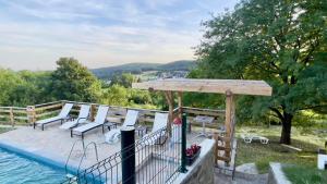 a deck with chairs and a view of the water at Apartmani Todorovic Ugore Vrdnik in Vrdnik