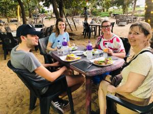 a group of people sitting at a table eating food at Villa Mango in Negombo