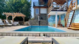 a swimming pool in a backyard with a house at Apartmani Todorovic Ugore Vrdnik in Vrdnik