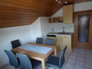 a kitchen with a wooden table and blue chairs at Haus Panorama in Massenbachhausen +6 photos