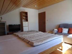 a bedroom with a large bed and a couch at Haus Panorama in Massenbachhausen
