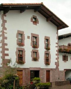 a white building with flower boxes on the windows at Casa rural Ballenea in Errazu +2 photos